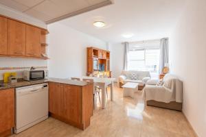 a kitchen and living room with a couch and a table at ELS BALADRES in Deltebre