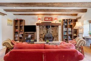 a living room with a red couch and a fireplace at Villa Esperance in Grand Brassac