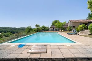 a swimming pool in a yard with a house at Villa Esperance in Grand Brassac