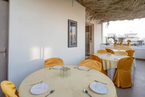 a dining room with a table and yellow chairs at Treebo Hub in Indore
