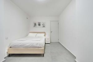 a bedroom with a bed and a white wall at Spacious Luxury Beach Getaway by Torohome in Ashdod