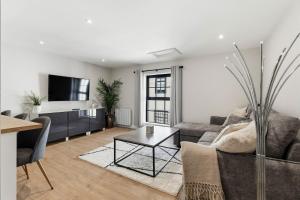 a living room with a couch and a table at Chic City Apartment in Wakefield