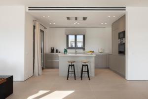 a kitchen with two bar stools and a counter at Celestial Villas in Santa Maria