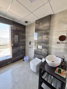 a bathroom with a sink and a toilet at Rumuk Boutique Resort - Offbeat escape in Dhanaulti