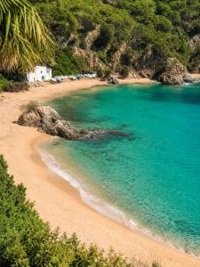 a beach with a group of tents and the ocean at Cala Canyelles Villa & Private Studio with Garden in Lloret de Mar