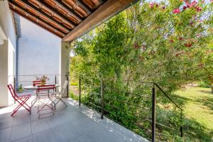 a balcony with a table and chairs and a tree at Gîte Gignac Vallée De L'hérault in Gignac
