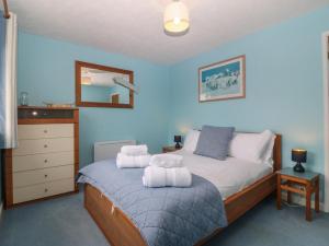 a bedroom with a bed with towels on it at Wingelock in Rhosneigr