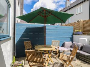 a table and chairs with an umbrella on a patio at Wingelock in Rhosneigr
