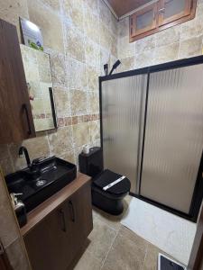 a bathroom with a black toilet and a sink at Ela Sultan Han Otel in Gaziantep