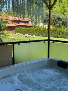 a bath tub with a herd of sheep in a field at Kominkowy Chill - Jacuzzi, Sauny & Wybrane apartamenty z prywatnym jacuzzi in Zakopane