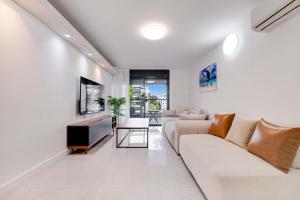 a living room with a couch and a tv at Spacious Luxury Beach Getaway by Torohome in Ashdod
