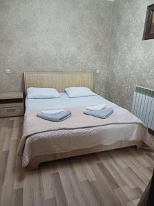 a bedroom with a bed with two towels on it at Your warm host in Kutaisi