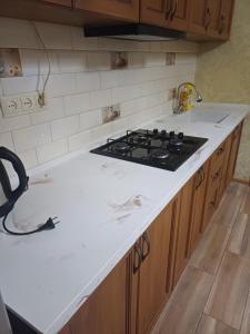 a kitchen with a stove and a white counter top at Your warm host in Kutaisi