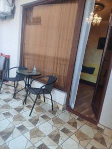 a table and chairs in a room with a glass door at Your warm host in Kutaisi