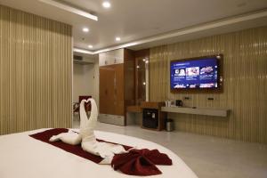 a hotel room with a bed and a flat screen tv at Briddhishree Palace in Guwahati