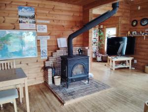 a fireplace in a room with a wooden wall at Siodomi Marinki shared wood lodge, pets allowed for a fee in Ōkuki