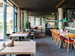 a restaurant with wooden tables and chairs and a bar at ibis Styles Nagold-Schwarzwald in Nagold