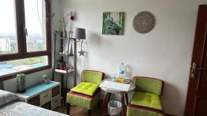 a bedroom with two chairs and a table and a bed at GAIA Hab doble con baño compartido in Bilbao
