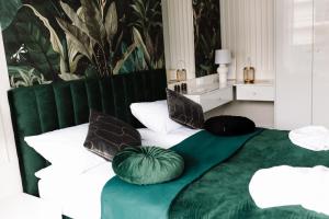 a green and white bed with pillows on it at GOLDEN HAUS Opole - Royal Blue & Royal Green in Opole