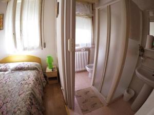 コティニョーラにあるLe due magnolieのベッドルーム1室(ベッド1台付)、バスルーム(シンク付)