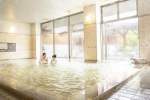 two people in the water in a swimming pool at Ooedo Onsen Monogatari Ureshinokan in Ureshino