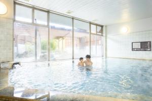 two people standing in a swimming pool at Ooedo Onsen Monogatari Ureshinokan in Ureshino +45 photos