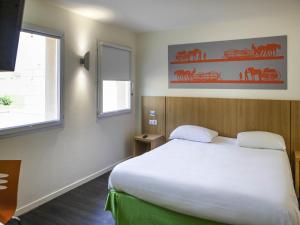 a bedroom with a large white bed and a window at ibis Styles Bourbon Lancy in Bourbon-Lancy