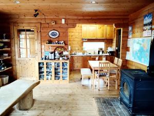 a kitchen with a table and chairs in a cabin at Siodomi Marinki shared wood lodge, pets allowed for a fee in Ōkuki