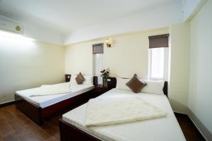 two beds in a room with two windows at SAMMY Hotel - Khách sạn SAMMY in Giáp Vinh Yên