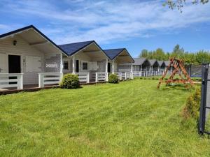 a row of houses with a playground in the yard at Domki nad morzem Jula in Wrzosowo