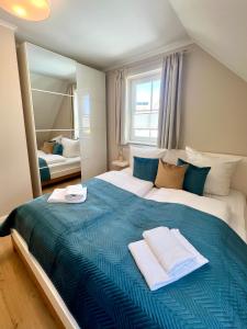 a bedroom with a large bed with towels on it at Ferienhaus Sundevit - exklusives Ferienhaus mit Infrarotsauna, Whirlpool-Wanne und Kamin in Putgarten +19 photos