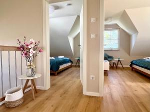 a room with two beds and a vase of flowers at Ferienhaus Sundevit - exklusives Ferienhaus mit Infrarotsauna, Whirlpool-Wanne und Kamin in Putgarten