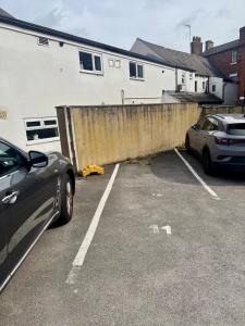 two cars parked in a parking lot next to a building at Chic City Apartment in Wakefield