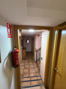 a hallway with a fire extinguisher on the wall at Hostal Arévacos in Soria +41 photos