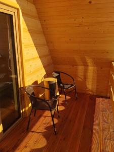 two chairs sitting on the porch of a cabin at Domek Niedźwiedź in Groń +28 photos