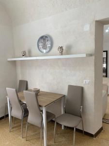 a dining room with a table and chairs and a clock at Sicilia Ambiente in Montedoro