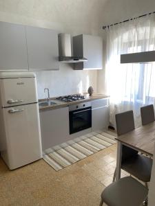 a kitchen with a white refrigerator and a sink and a table at Sicilia Ambiente in Montedoro