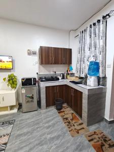 a kitchen with a sink and a stove at Stylish Mtwapa Studio with Rooftop Pool View in Mtwapa