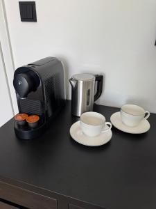 two coffee cups on a counter next to a microwave at Westerntor City Studio in Paderborn