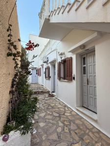 a stone walkway between two white buildings at Anassa Homes Leros in Agia Marina