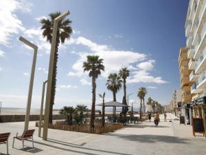 a street with palm trees on the beach at Résidence de Noëlle in Canet-en-Roussillon
