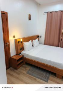 a small bedroom with two beds and a curtain at Résidence saint Daniel in Cotonou