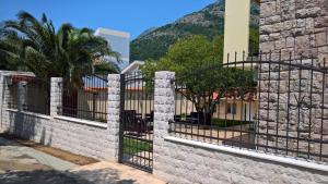 a stone fence with a gate in front of a building at Apartments Villa Jagoda in Sutomore
