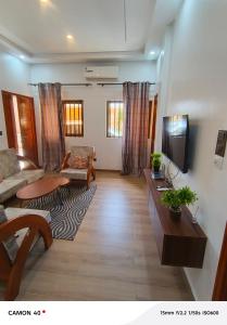 a living room with a couch and a tv at Résidence saint Daniel in Cotonou