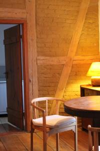 a wooden room with a table and a chair at Charmante Ferienwohnung in einzigartiger Anlage - Büdnerei Lehsten in Möllenhagen