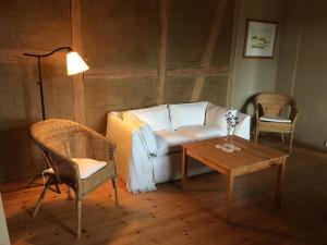 a living room with a couch and a table at Charmante Ferienwohnung in einzigartiger Anlage - Büdnerei Lehsten in Möllenhagen