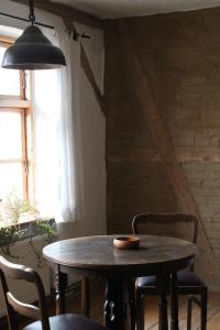 a table and chairs in a room with a window at Charmante Ferienwohnung in einzigartiger Anlage - Büdnerei Lehsten in Möllenhagen +24 photos