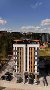 a building under construction with cars parked in a parking lot at Hedonist Wellness & Spa in Zlatibor