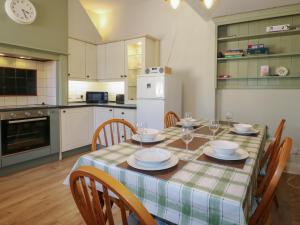 a kitchen with a table and chairs and a kitchen with a table and chairsktop at The Old School House in Chichester