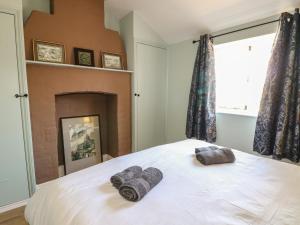 a bedroom with a bed with two towels on it at The Old School House in Chichester